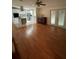 Open-concept floor plan showcasing wood floors, a kitchen with an island cooktop, and sliding glass doors at 3124 Pond Hollow St # 183, Wesley Chapel, FL 33543