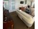 Bright living room featuring a piano, sofa, entertainment center, and glass doors for lots of natural light at 3124 Pond Hollow St # 183, Wesley Chapel, FL 33543