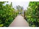 Wooden walkway leading to a boat dock with a boat in the water at 5169 Oxford Dr, Sarasota, FL 34242