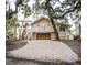Two-story home with a balcony, stairs, a two car garage and a long paved driveway at 5169 Oxford Dr, Sarasota, FL 34242