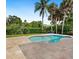 Backyard view featuring a freeform pool surrounded by lush tropical landscaping at 5169 Oxford Dr, Sarasota, FL 34242
