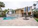 Back exterior showcasing a kidney-shaped pool, patio and tan two-story home at 5169 Oxford Dr, Sarasota, FL 34242