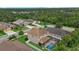 Aerial view showcasing a two-story home with lush green backyard and screened pool at 7114 Mill Hopper Ct, Palmetto, FL 34221