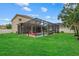 Green backyard featuring a screened-in pool with a flamingo float at 7114 Mill Hopper Ct, Palmetto, FL 34221