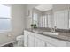 This bathroom features a gray granite countertop, a large mirror and a window at 7114 Mill Hopper Ct, Palmetto, FL 34221