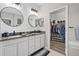 Well-lit bathroom featuring double vanity, granite countertops, round mirrors, and a closet with closet system at 7114 Mill Hopper Ct, Palmetto, FL 34221