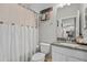 Cozy bathroom with a shower curtain featuring decorative buttons, a toilet and a modern sink at 7114 Mill Hopper Ct, Palmetto, FL 34221