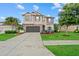 A stately two-story home with a stone facade, a well-manicured lawn, and a comfortable outdoor seating area in the front yard at 7114 Mill Hopper Ct, Palmetto, FL 34221