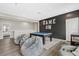 Entertainment room with a pool table, comfortable seating, and accent wall with neon 