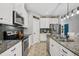 Well-equipped kitchen with stainless steel appliances, granite countertops, and white cabinetry for ample storage at 7114 Mill Hopper Ct, Palmetto, FL 34221
