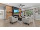 Cozy living room featuring a rustic wood accent wall, fireplace, and comfortable seating at 7114 Mill Hopper Ct, Palmetto, FL 34221