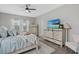 Serene bedroom with light blue bedding, natural light, wood floors, and contemporary decor at 7114 Mill Hopper Ct, Palmetto, FL 34221