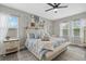 Inviting bedroom with light blue bedding, a cozy seating area, and soft natural lighting, ready for relaxation at 7114 Mill Hopper Ct, Palmetto, FL 34221
