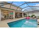 Beautiful screened-in pool with ample seating, an outdoor bar, and tropical landscaping at 7114 Mill Hopper Ct, Palmetto, FL 34221