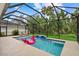 Relax in this screened-in pool featuring a waterfall and an adorable pink flamingo float at 7114 Mill Hopper Ct, Palmetto, FL 34221