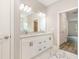 Bathroom with double sinks, white cabinets, marble countertops and floors, and a walk-in closet nearby at 14362 San Domingo Blvd, Port Charlotte, FL 33981