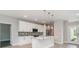 Modern kitchen with white cabinets, stainless steel appliances, a mosaic backsplash, and an island with pendant lighting at 14362 San Domingo Blvd, Port Charlotte, FL 33981