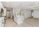 Bright open-plan kitchen features an island with seating, modern appliances, and wood-look flooring at 14362 San Domingo Blvd, Port Charlotte, FL 33981