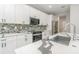 Bright kitchen featuring white cabinets, granite countertops, stainless appliances and hardware, plus tiled backsplash at 14362 San Domingo Blvd, Port Charlotte, FL 33981