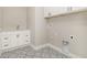 Charming laundry room with white cabinets, decorative tile flooring and modern hardware at 14362 San Domingo Blvd, Port Charlotte, FL 33981