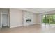 Bright open-plan living room with wood-look flooring, modern fireplace, and sliding glass doors to outside at 14362 San Domingo Blvd, Port Charlotte, FL 33981