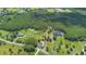 Estate aerial view featuring multiple homes, a large pond, and expansive grounds at 11933 Pasco Trails Blvd, Spring Hill, FL 34610