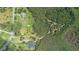 An aerial view shows multiple residences situated amidst wooded land with private drives and ponds at 11933 Pasco Trails Blvd, Spring Hill, FL 34610