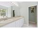 Bright bathroom featuring a double sink vanity, large mirror, and view from the window at 11933 Pasco Trails Blvd, Spring Hill, FL 34610