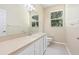 Bright bathroom featuring a single sink vanity, large mirror, and window at 11933 Pasco Trails Blvd, Spring Hill, FL 34610