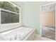 Bright bathroom featuring a soaking tub and a window, offering a relaxing view at 11933 Pasco Trails Blvd, Spring Hill, FL 34610