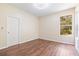 Light-filled bedroom with wood floors, a window, and fresh white trim at 11933 Pasco Trails Blvd, Spring Hill, FL 34610