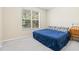 Cozy bedroom with a blue bed, large window, and neutral walls at 11933 Pasco Trails Blvd, Spring Hill, FL 34610
