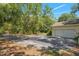 Long driveway leading to a spacious two-car garage in a wooded area at 11933 Pasco Trails Blvd, Spring Hill, FL 34610