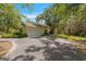 Driveway with ample parking space and mature landscaping around the perimeter of the home at 11933 Pasco Trails Blvd, Spring Hill, FL 34610