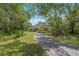 Single story home with green grass and long driveway at 11933 Pasco Trails Blvd, Spring Hill, FL 34610