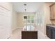 Kitchen area features a large center island with granite countertop and modern light fixture at 11933 Pasco Trails Blvd, Spring Hill, FL 34610