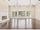 Bright living room with a cozy fireplace and elegant chandeliers at 11933 Pasco Trails Blvd, Spring Hill, FL 34610