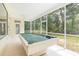 Spacious screened patio featuring a pool table and backyard views at 11933 Pasco Trails Blvd, Spring Hill, FL 34610
