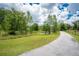 Scenic view of property with an adjacent pond and an asphalt drive running along its perimeter at 11933 Pasco Trails Blvd, Spring Hill, FL 34610