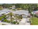 Aerial view of single-story home with a driveway, backyard, and surrounding greenery at 6012 1St W Ave, Bradenton, FL 34209