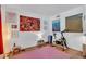 Bright bedroom area with workout equipment, light wood flooring, and colorful accent wall art at 6012 1St W Ave, Bradenton, FL 34209