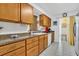 Kitchen with wood cabinets, tile floors, sink and faucet, dishwasher and a view of the adjacent room at 6012 1St W Ave, Bradenton, FL 34209