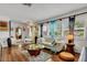Bright living room featuring wood floors, a white sofa, and large windows with plantation shutters at 6012 1St W Ave, Bradenton, FL 34209