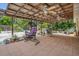 Covered outdoor patio with a hanging chair, ceiling fans, brick pavers, and lush landscaping at 6012 1St W Ave, Bradenton, FL 34209