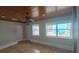 Bright bedroom features tile floors, ceiling fan, and two windows overlooking backyard at 3510 Magnolia Way, Punta Gorda, FL 33950