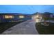 Charming home at dusk, illuminated by interior lights, features a concrete driveway and well-kept lawn at 3510 Magnolia Way, Punta Gorda, FL 33950