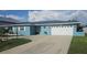 Charming blue one-story home with a well-manicured lawn and a spacious driveway leading to an attached two-car garage at 3510 Magnolia Way, Punta Gorda, FL 33950