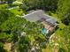 This aerial view highlights a private screened-in pool in the backyard, surrounded by lush, mature landscaping at 6049 Patricia Pl, Weeki Wachee, FL 34607