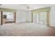 Bright bedroom featuring neutral carpet, ceiling fan, and sliding glass doors at 6049 Patricia Pl, Weeki Wachee, FL 34607