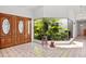 An inviting home foyer featuring tile flooring and large windows with tropical plants at 6049 Patricia Pl, Weeki Wachee, FL 34607